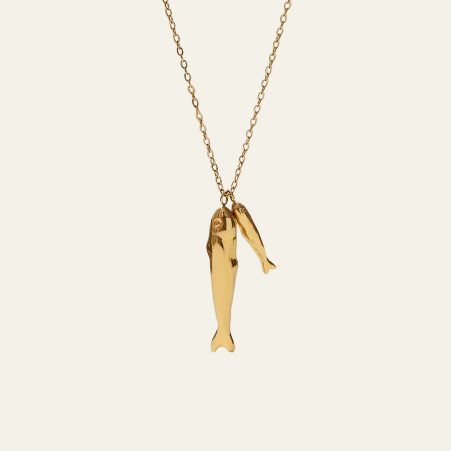 Gold fish-shaped pendant on a chain against a white background