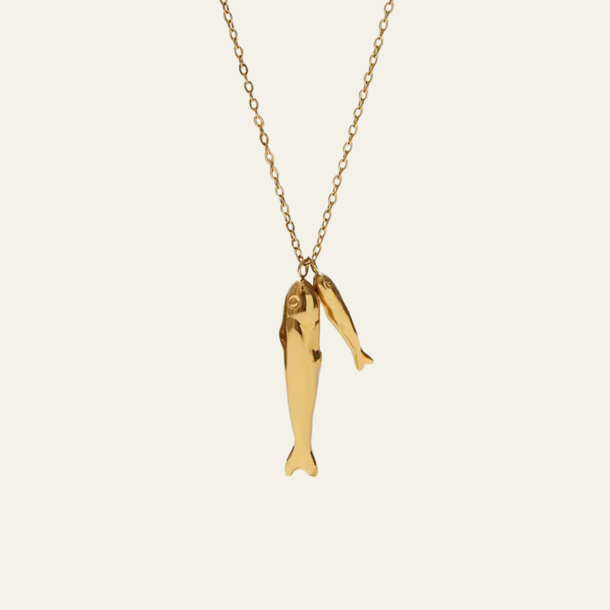 Gold fish-shaped pendant on a chain against a white background