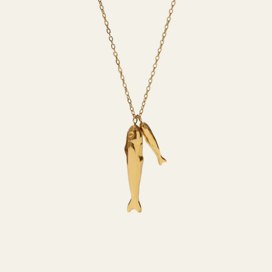 Gold fish-shaped pendant on a chain against a white background